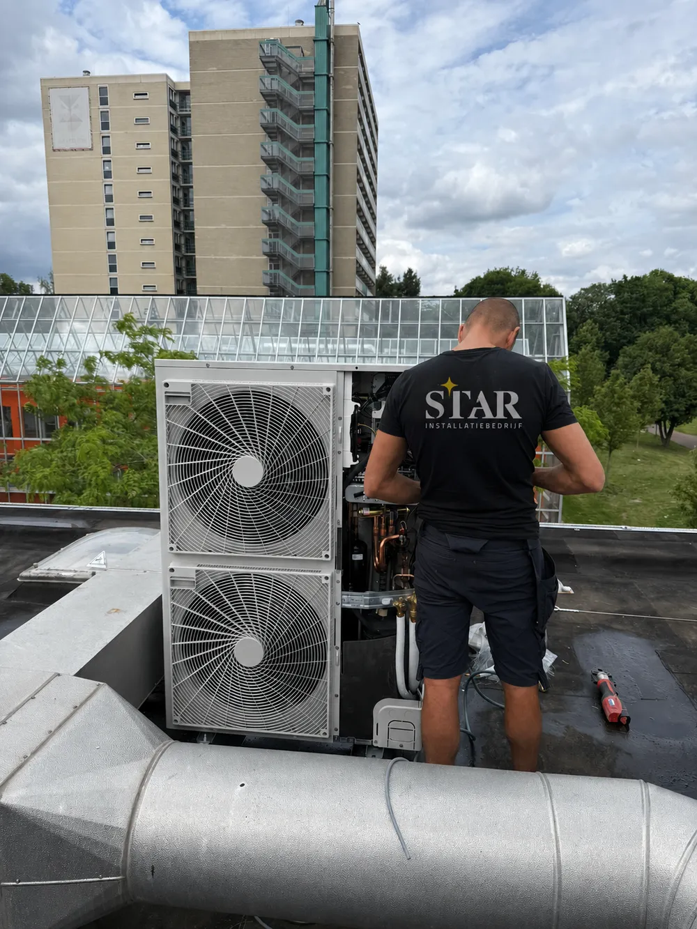 Montage van een airco buitenunit op een dak
